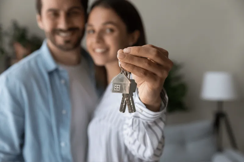 woman holding sets of key on hand with husband